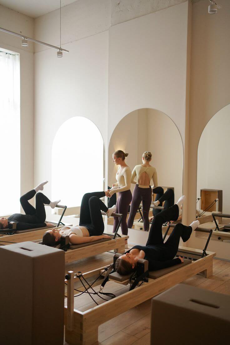 Zajęcia pilates na reformerach w jasnym studio.